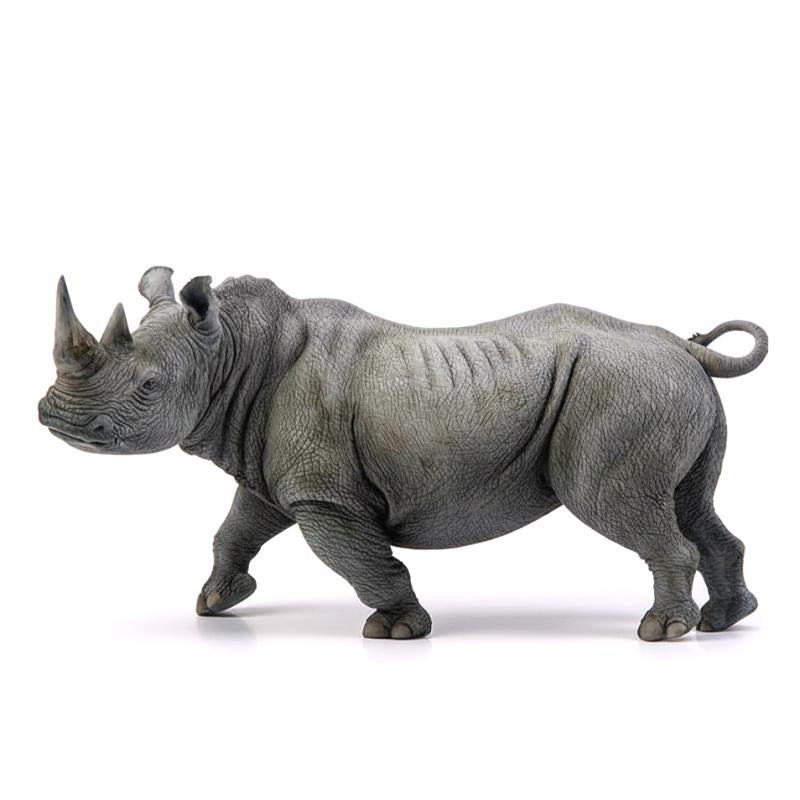Figurine détaillée d'un rhinocéros blanc en position de repos, expression sereine.