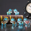 Statuettes bande d'elephants en verre posees sur un bureau