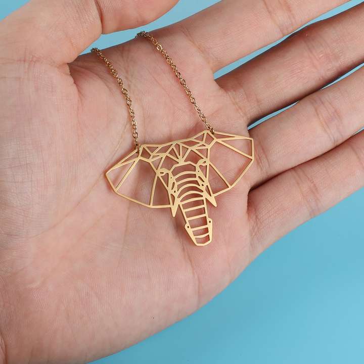 Collier elephant origami dans une main