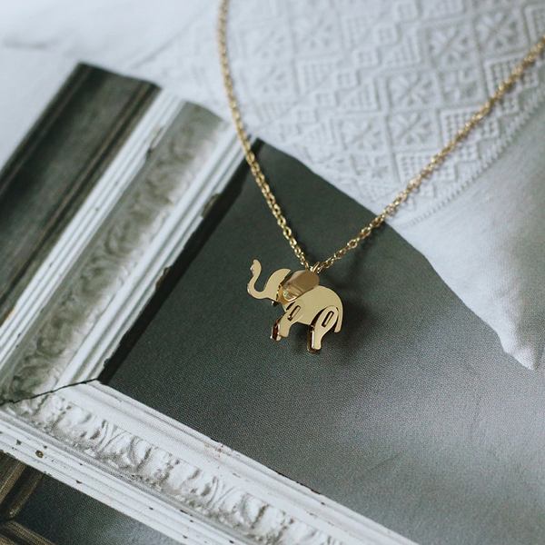 Collier elephant en titane posé sur un drap