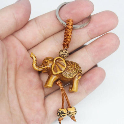 Porte-clef elephant bois dans une main