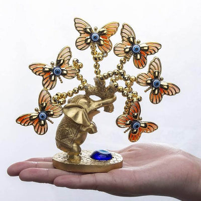 Statue éléphant papillons posé sur une main